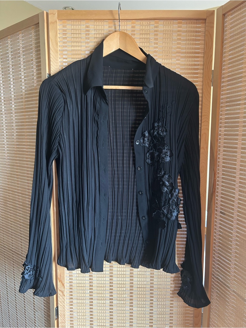 Pleated black blouse with flower embellishments